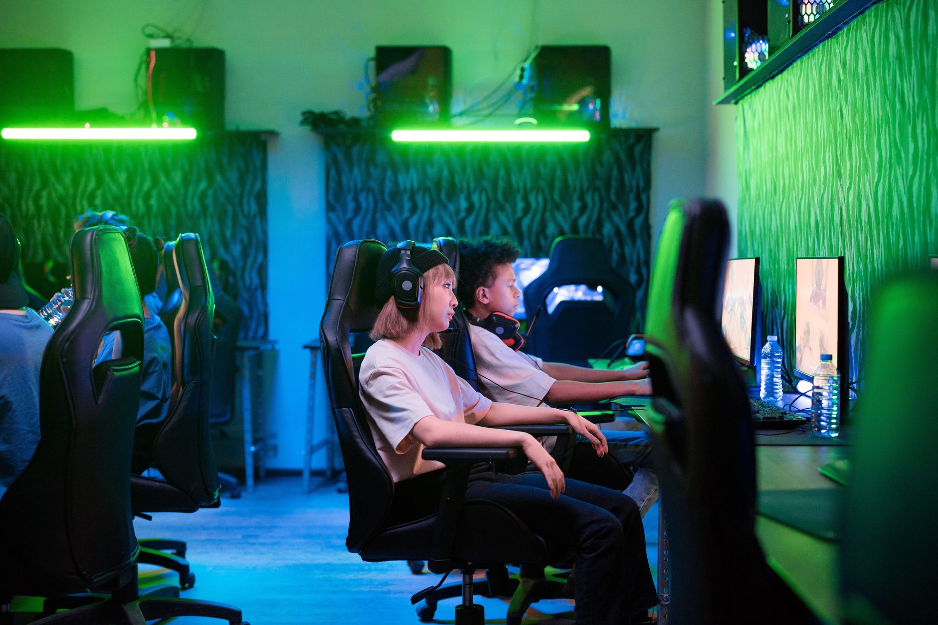 Neon-lit YOYO computer club hall at night with rows of gaming stations